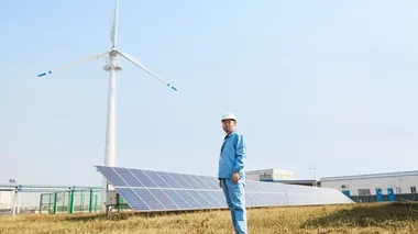 Ein Mann, vor Solarmodulen stehend